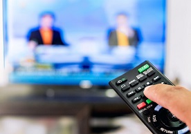 hand with a channel remote and TV screen in the background